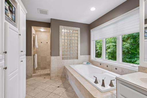 Melt away the day in the luxurious soaking tub or refresh in the spacious walk-in shower, where the glass block wall fills the space with soft natural light while maintaining privacy.