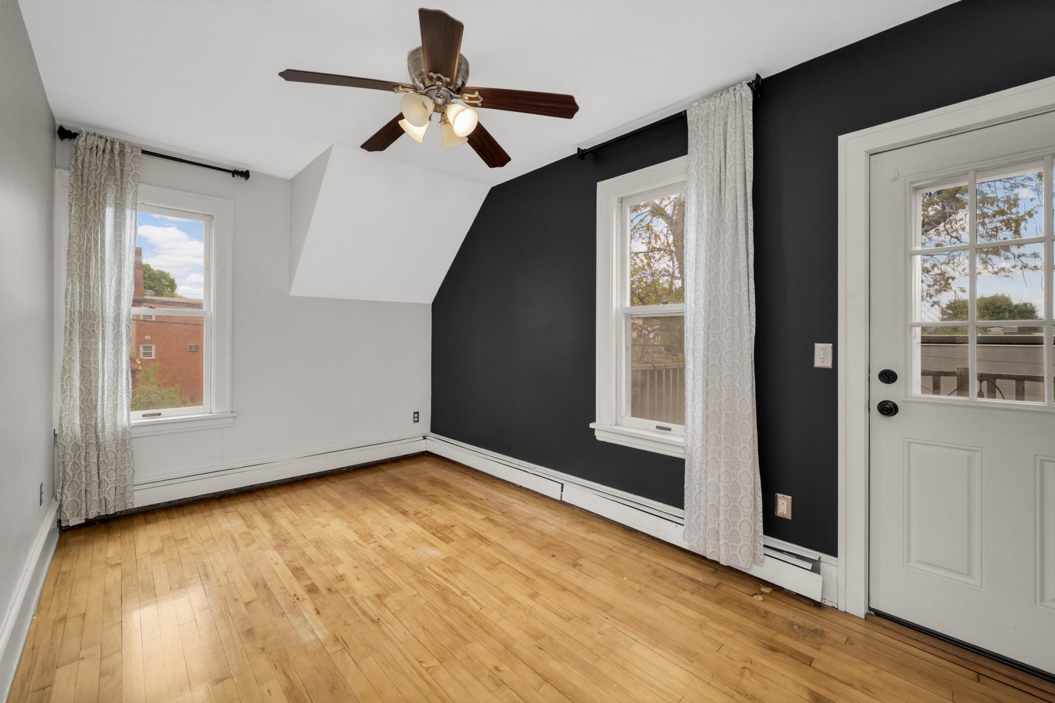This spacious bedroom has a walk-in closet and a doorway that leads out to a balcony