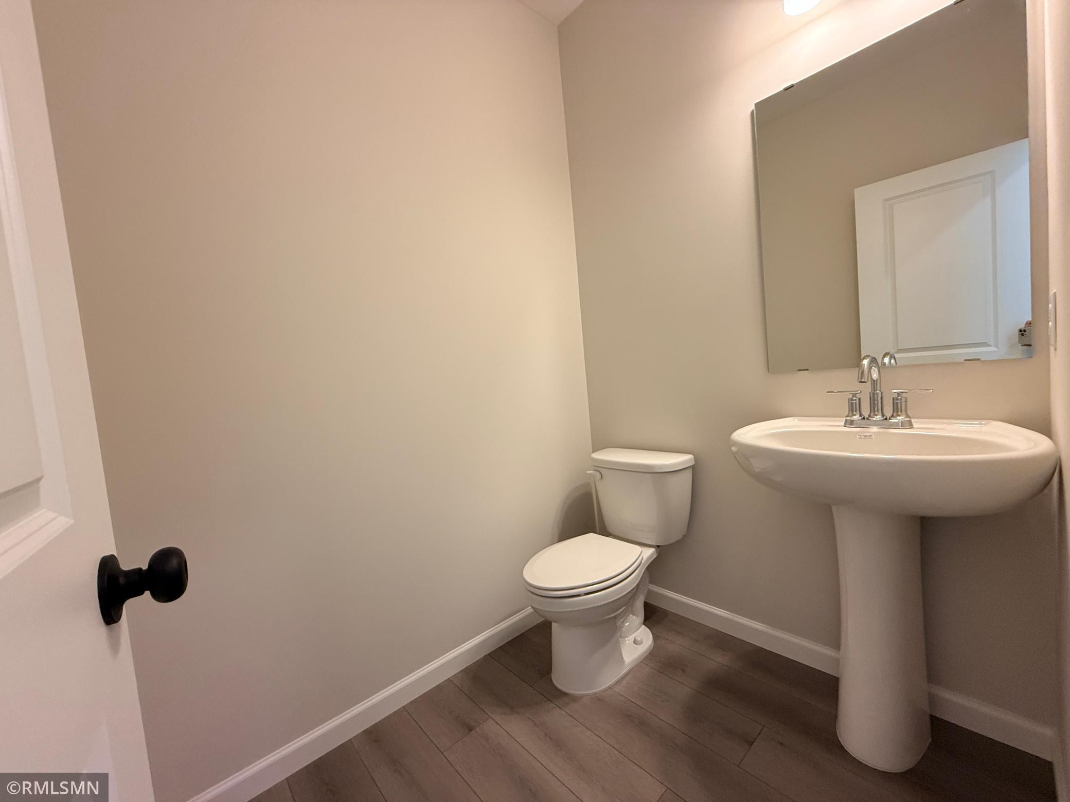 The powder room is located handily near the garage entry.