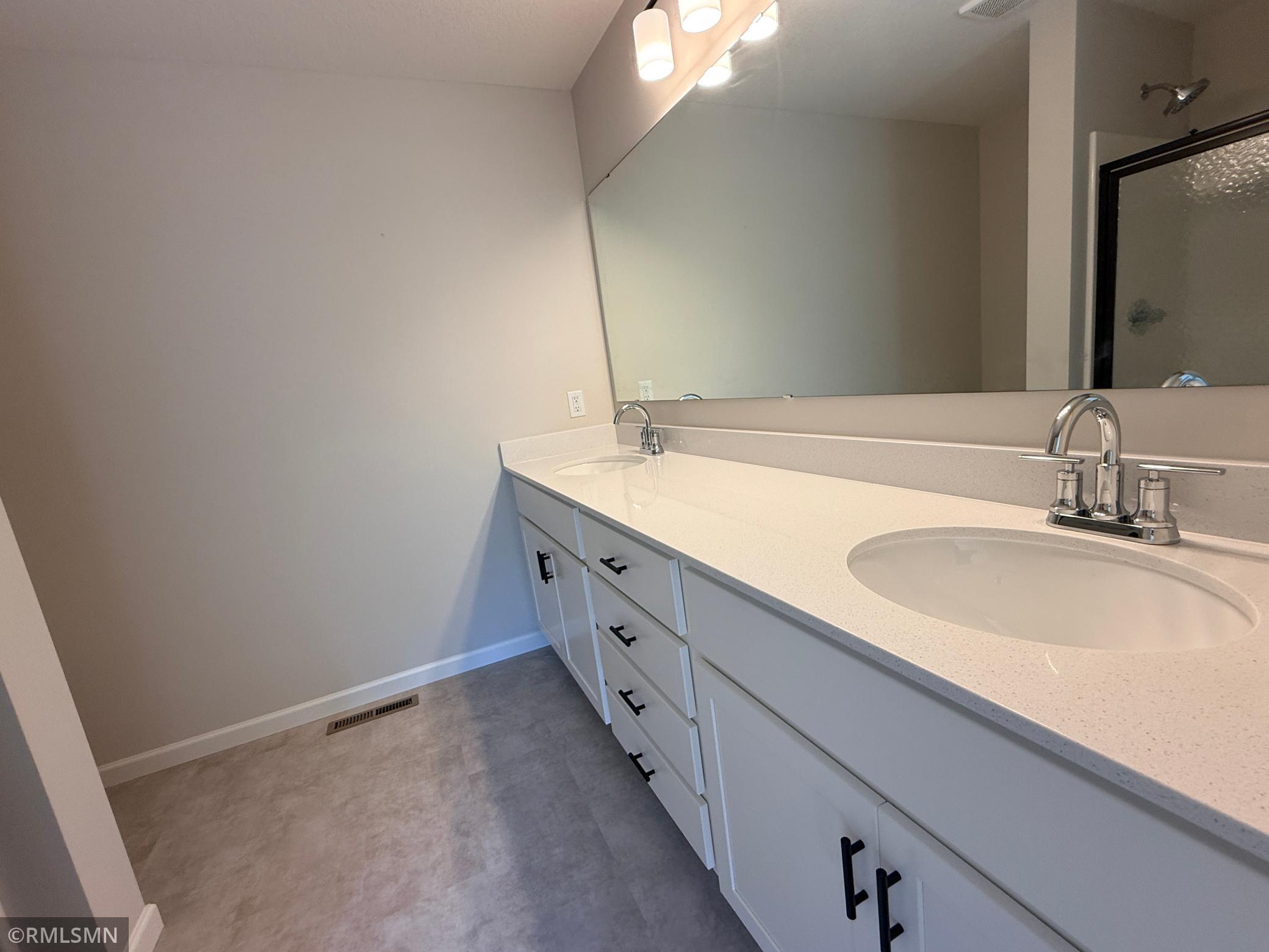 Double sinks and a spacious vanity are the perfect fit for the owner's suite bathroom.