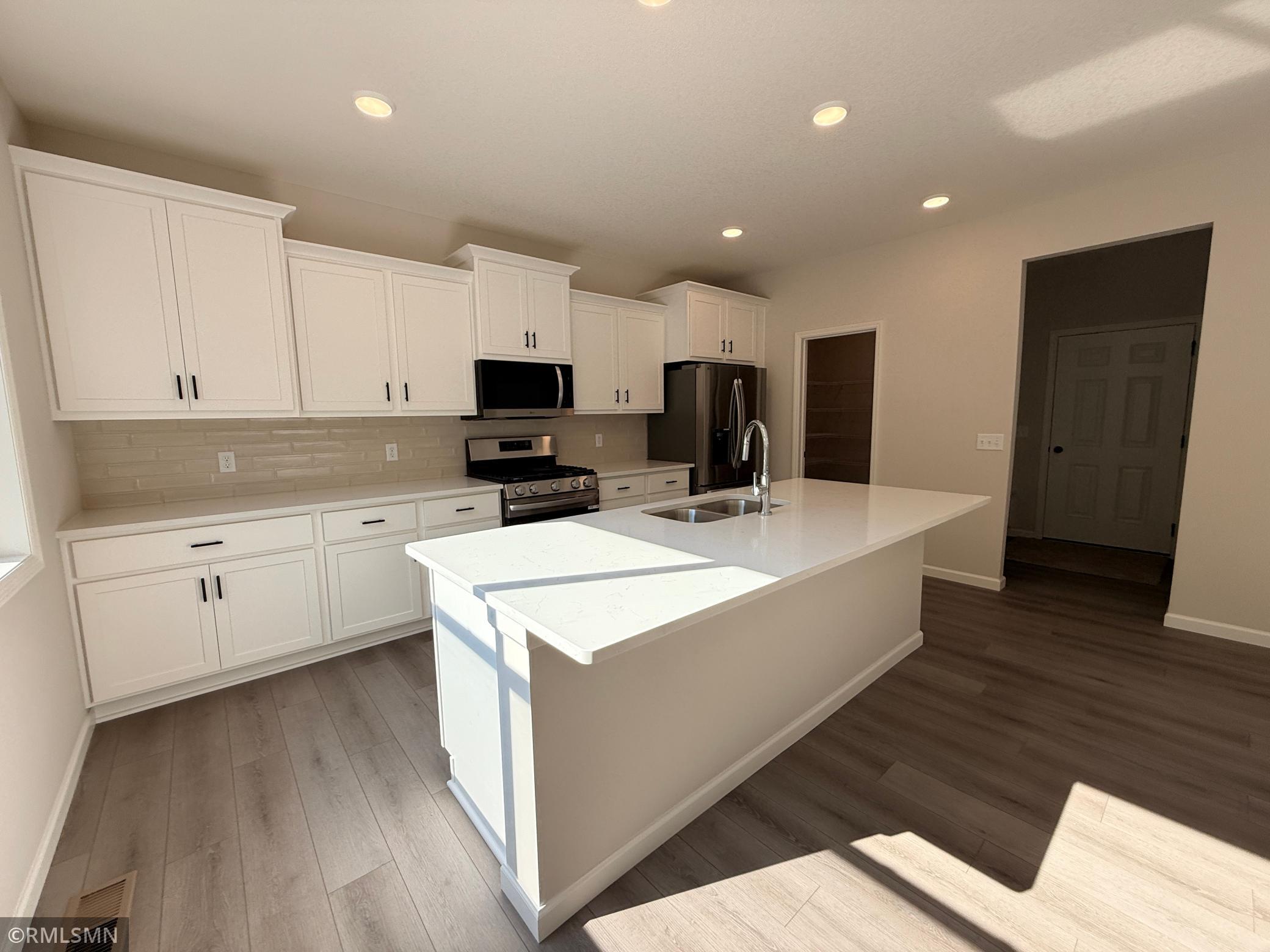 Loads of cabinetry and a huge island make this kitchen the heart of your home.