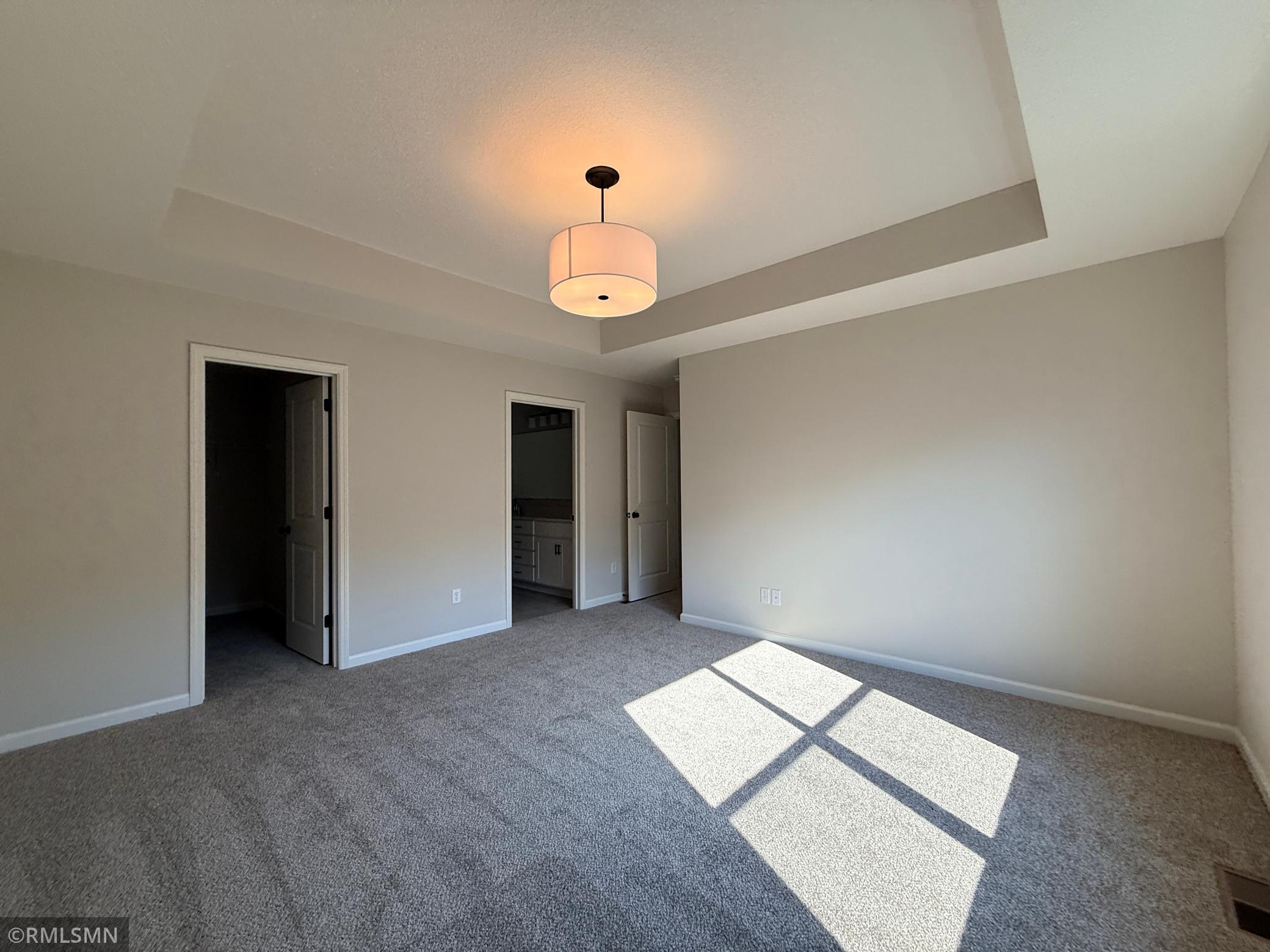 Opposite view of owner's suite showing closet entrance, bathroom entrance and hallway entrance.