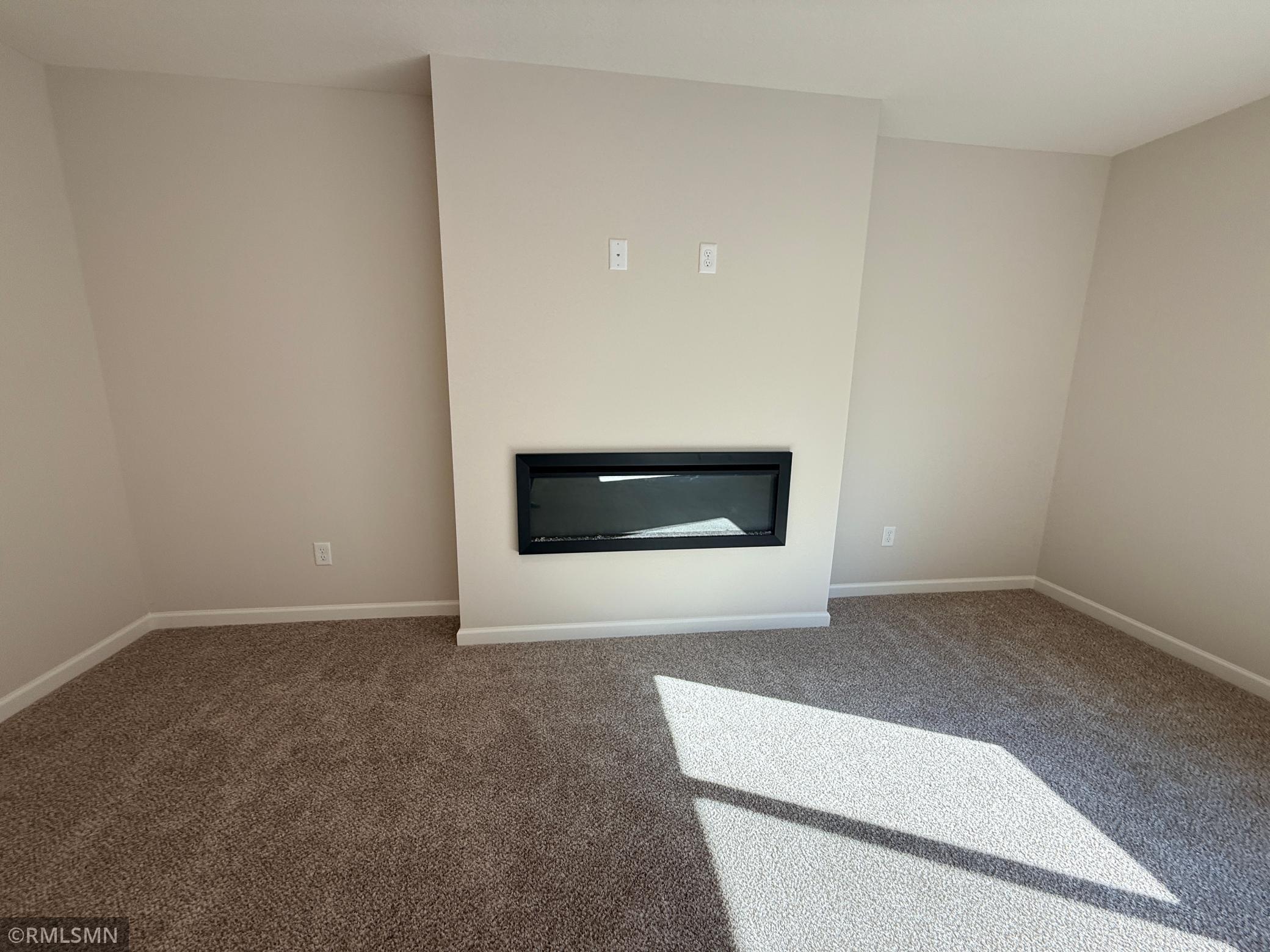 The lower level family room includes a 2nd fireplace - this one is a sleek electric fireplace!