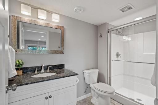 Lower level 3-quarter bathroom with granite countertop vanity