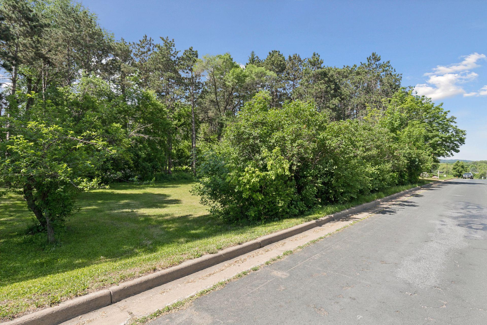 Peaking in the lot from Krattley Ln N around mature vegetation.