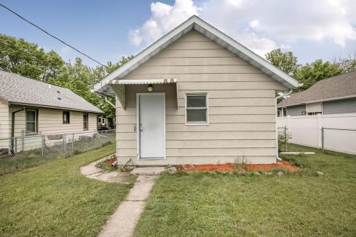 Cement sidewalk traverses from the detached garage to the back entrance of the house where an awning gives you a bit of coverage when unlocking the door.