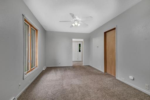 The main living area feels inviting and functional, complete with a ceiling fan operated by remote control in the living room.