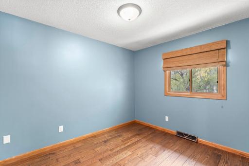 Two upper-level bedrooms feature cohesive hardwood flooring.