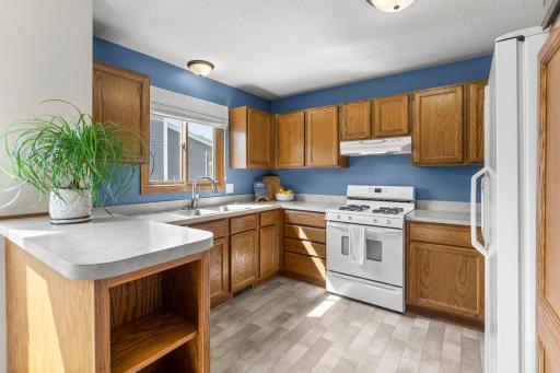 The upper-level kitchen offers abundant wood cabinetry.