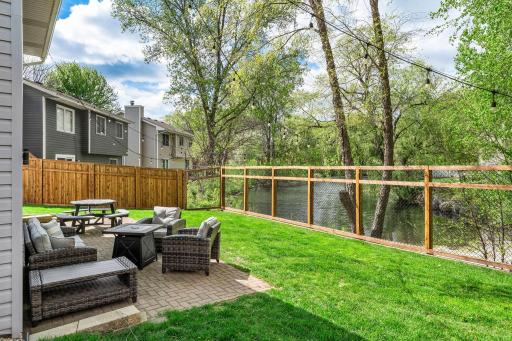 Privacy fencing lines the sides of the yard, while a California-style chain-link fence in the rear preserves the beautiful pond views and peaceful green surroundings.