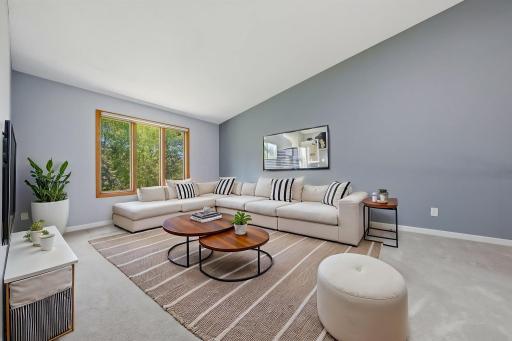 Upper level living room features beautiful views of the outdoor space. (virtually staged)