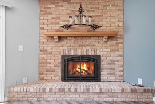 Family room features gas fireplace w/ brick surround.