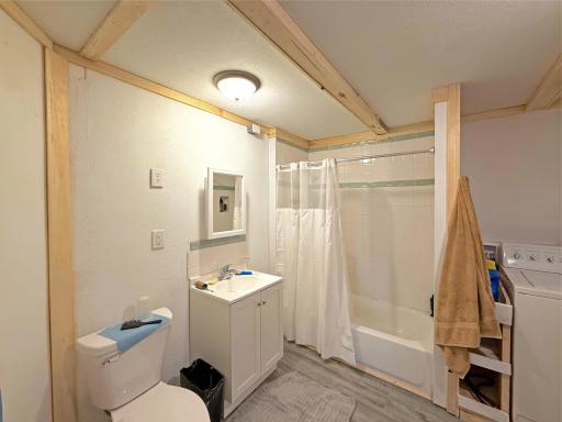 This spacious full bathroom combines practicality and comfort with a tub/shower surround, updated vanity, and easy-care flooring.