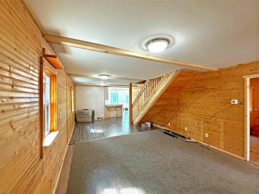 Warm and inviting, the spacious living and dining area is wrapped in rich knotty pine walls that create a cozy atmosphere.