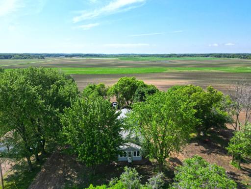 Set on a spacious parcel surrounded by productive farmland, the property features a detached garage and a peaceful setting.