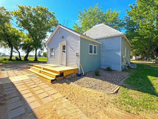 The exterior showcases the home's recent updates with attractive siding, a newer front entry deck, and paver stepping stones.