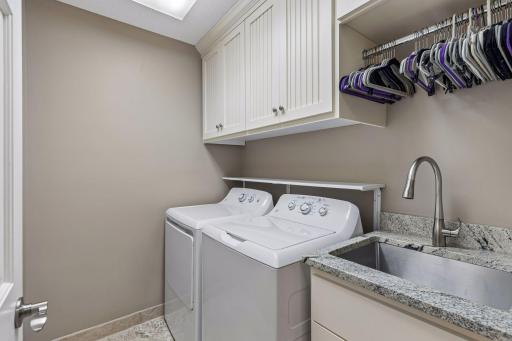 Upper level laundry room with sink and storage space