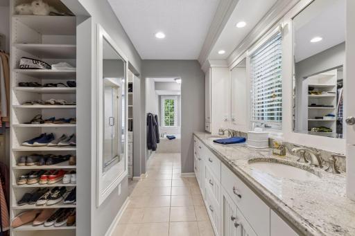 Primary bathroom features double sinks, natural light, and a great his and her closets