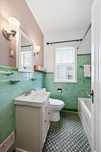 Main floor bathroom maintains the original classic tile but has been updated with a newer toilet and bath faucets.