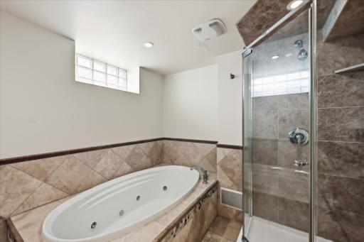 Lower level bath has a separate glass shower and heated floors.