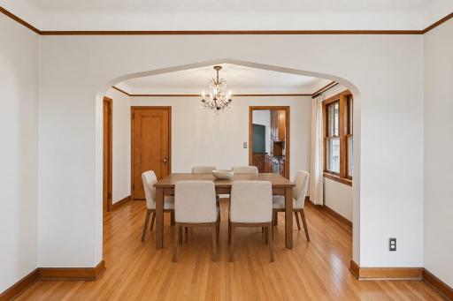 2nd view of dining room, virtually staged. Note the original hardwood floors and detailing such as the archway.