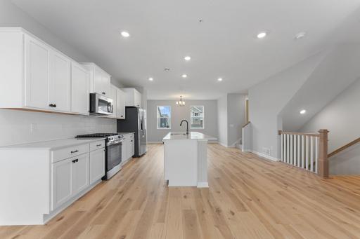 The open concept layout with luxury vinyl plank floors seamlessly connects the main living areas. Similar home shown, Color and options can vary.
