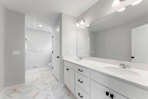Owner's en-suite bath includes a large dual sink vanity with huge linen closet. Similar home shown, Color and options can vary.