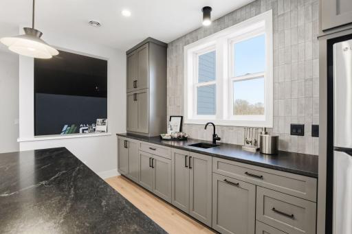 Lower Level Wet Bar with views of the Golf Sim