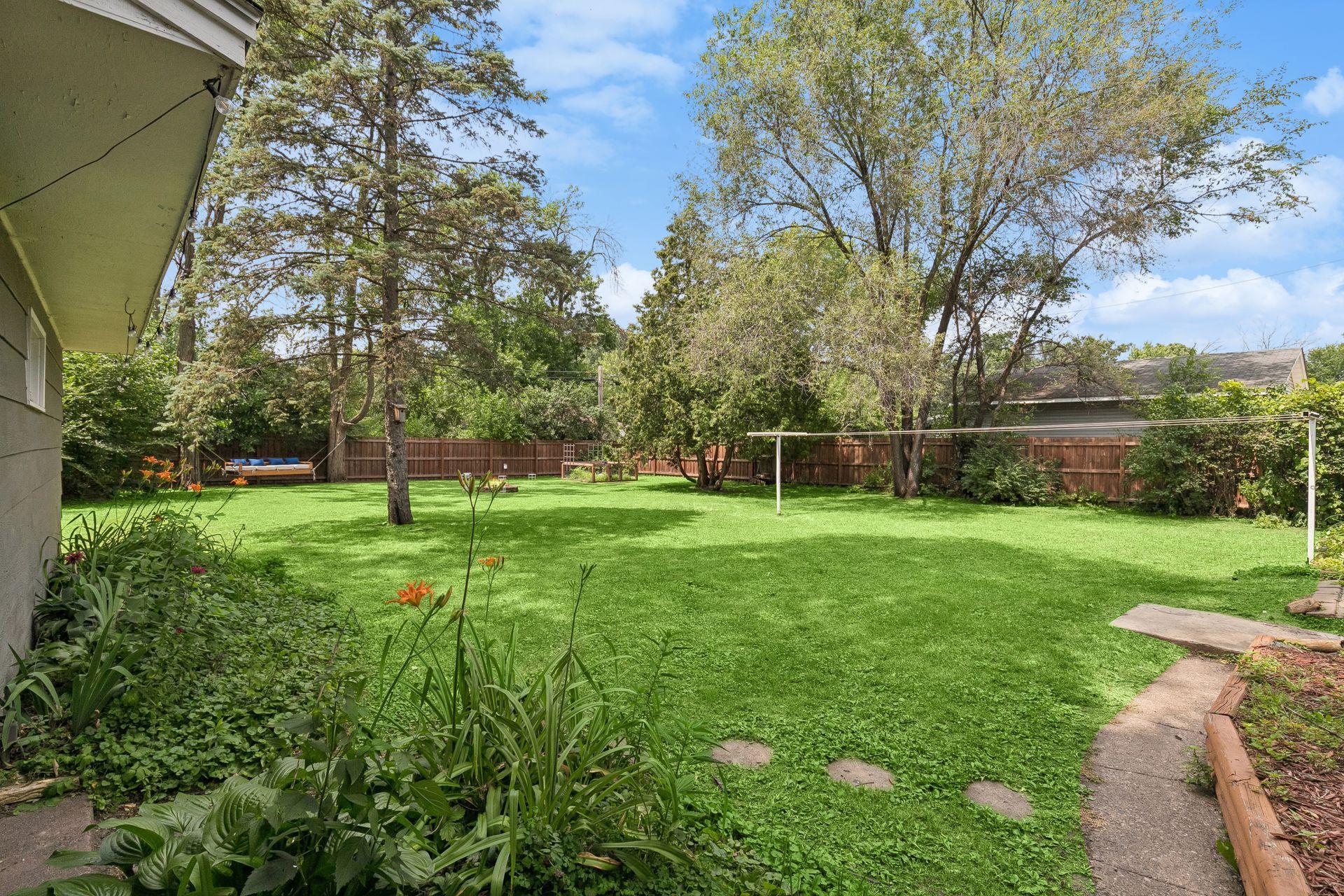 A stone path winds through the garden, adding charm to the backyard retreat.