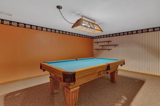 The basement rec room comes complete with the pool table, assessories and decor.
