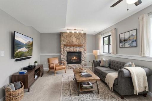 Living Room with brand new carpet and paint, a gorgeous stone fireplace surrounded by neutral tones, and a bar for hosting gatherings. AI used for furniture