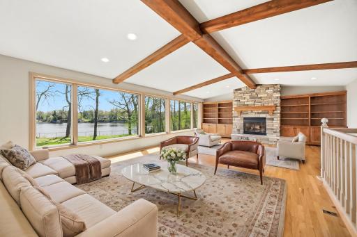 Light and bright vaulted living room welcomes you upon entry. Room features hardwood floors, newer windows, stone stacked gas fireplace, quality built ins, wood beams. Photo is virtually staged.
