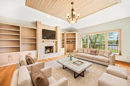 Main floor family room with vaulted ceilings and gas burning fireplace and built ins. Photo is virtually staged.
