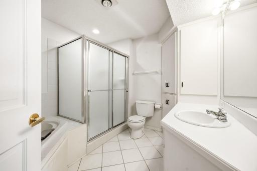 Lower level full bath with separate tub & shower. Located just off the lower kitchen that walks out to poolside. All tiled flooring from bath to poolside patio doors!