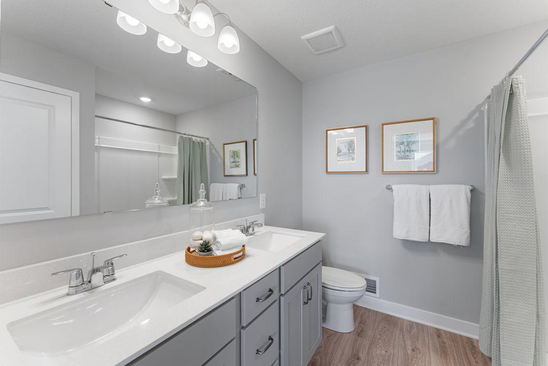Primary bathroom with raised height vanity and dual sinks. Photo is of model home. Colors and options may vary. Ask Sales Agent for details.