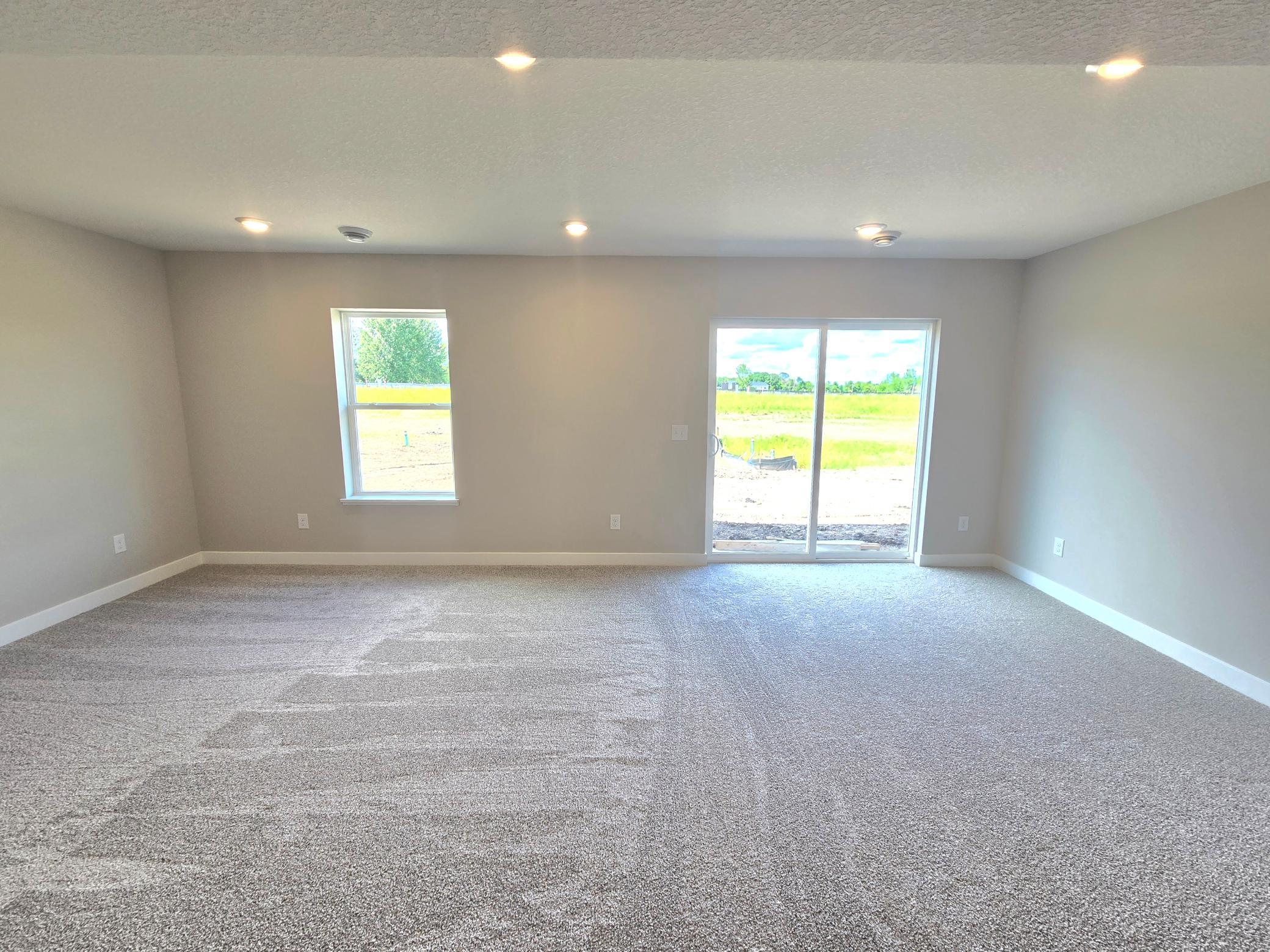 The Bryant II Walkout Lower Level Family Room at Highlands at Eagle View in Elko New Market. Photo is of actual home. Options and colors may vary. Ask Sales Agent for details.