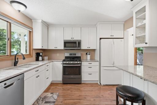 Sunlight flows into the kitchen area plus tons of counter space for meal prep and lots of cabinets for storage.