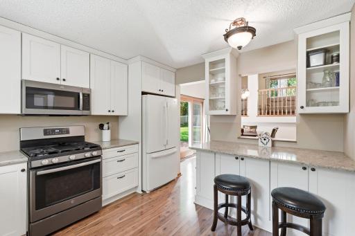 The stunning remodeled kitchen on the main level of the home complete with a breakfast nook area and opens to the dining room. White cabinetry and granite countertops!