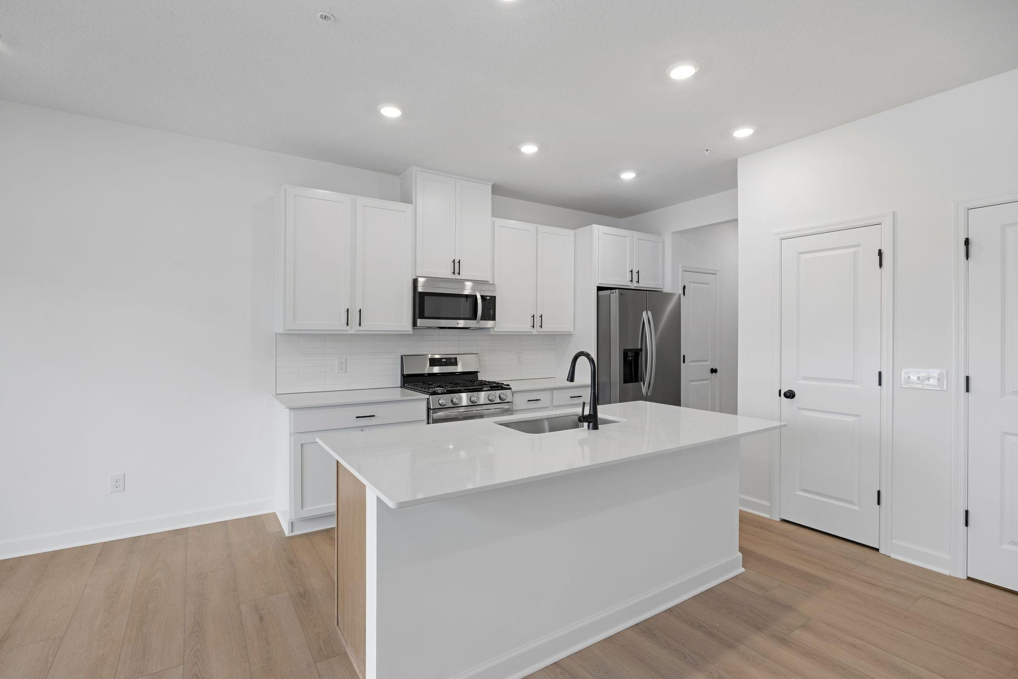 This chef-ready kitchen is designed to accommodate modern living, with a multiuse center island to add food prep and seating space, gleaming quartz countertops and abundant cabinetry room..jpg