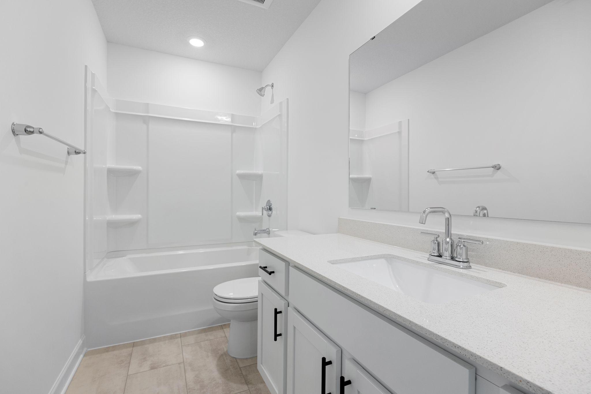 A full-sized bathroom on the second floor comes well-equipped with a generously sized quartz-topped vanity and a combination shower and tub to maximize the interior space.