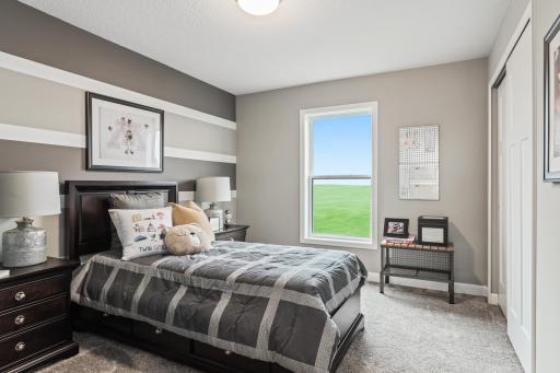 (Photo of a decorated model, actual homes finishes will vary) The second generously sized upper level secondary bedroom with a spacious closet.