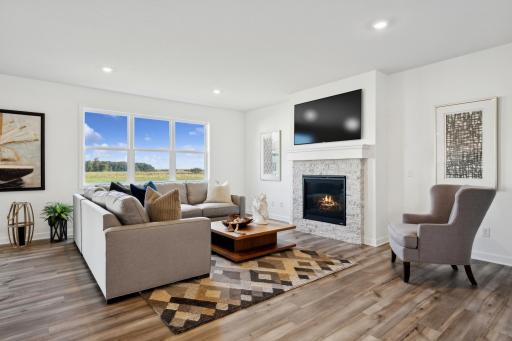 (Photo of a decorated model, actual homes finishes will vary) The stunning fireplace in the great room! Note: the fireplace will be a different color and electric.