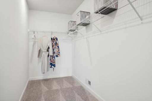 (Photo of a decorated model, actual homes finishes will vary) The primary bedroom walk-in closet.