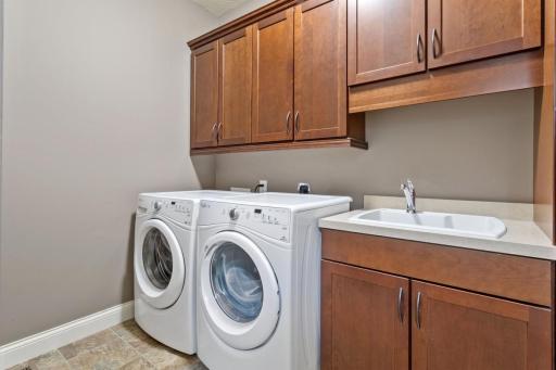 Main level laundry upgraded with built in cabinets and sink. Gas or Elec dryer hookups