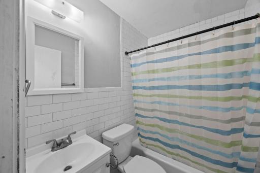 Unit 1 - Full bathroom features tile surround throughout