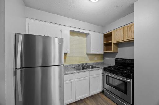 Unit 2 - Kitchen complete with stainless steel appliances featuring a gas stove and tile backsplash.