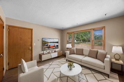 Unit 4 - Living room featuring oversized windows and a bright, open feel.