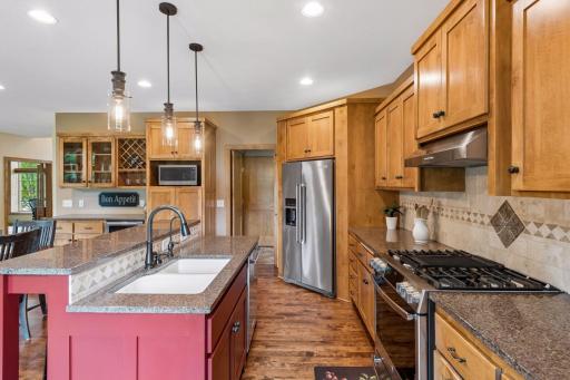 Warm custom cabinetry, stainless steel appliances, a gas range, and distinctive center island