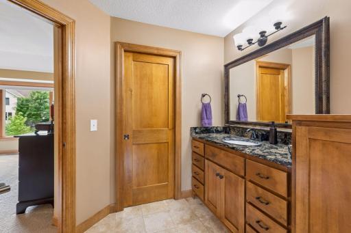 Primary bath with dual individual vanity spaces and entrance to walk in closet