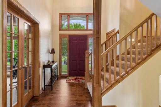 The impressive foyer offers a memorable welcome, showcasing soaring ceilings, extensive woodwork, a grand staircase, and a private main-floor office behind French doors